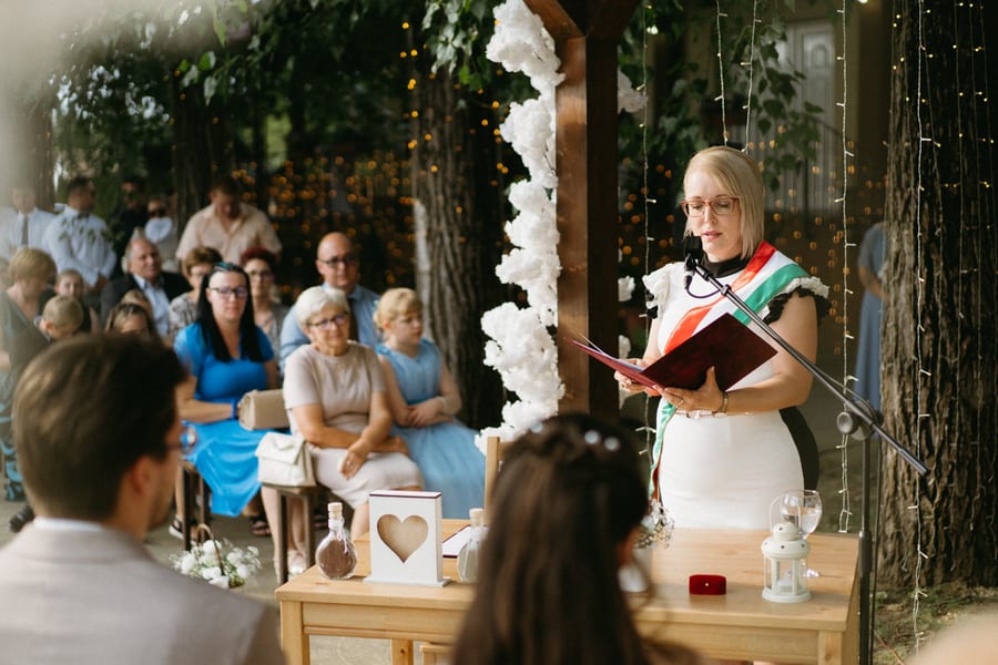 Mosolygó pár szabadtéri esküvői pillanatban.